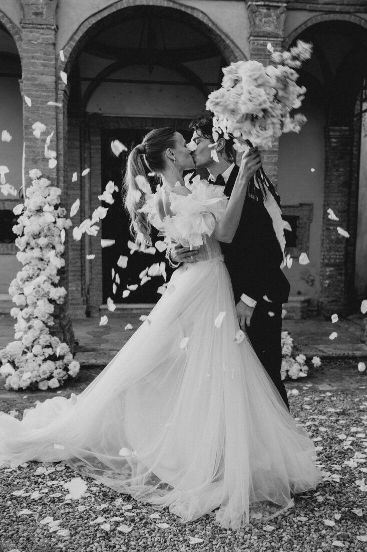 Braut und Bräutigam beim Kuss unter fallenden Blütenblättern am Bodensee