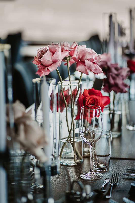 Detailaufnahme einer Hochzeitstischdekoration von pinken Rosen in einer Vase - Hochzeitsfotograf Tirol