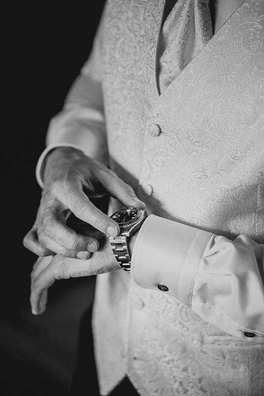 Der Bräutigam stellt gerade die Uhrzeit seiner Rolex am Handgelenk richtig ein - Hochzeitsfotograf Rufana Alp