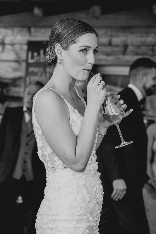 Braut trinkt entspannt einen Cocktail während der Hochzeitsfeier auf der Rufana Alp in Tirol – natürliche Hochzeitsreportage von Patricia Hamann