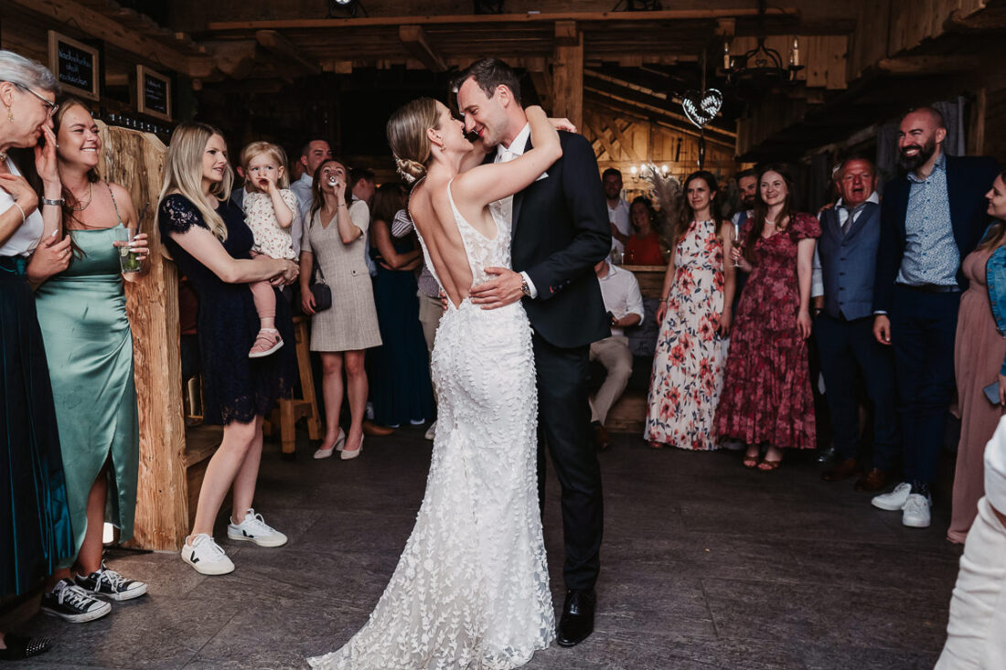 Braut und Bräutigam tanzen ihren ersten Tanz auf der Rufana Alp in Tirol, umgeben von ihren Gästen – natürliche Hochzeitsreportage von Patricia Hamann