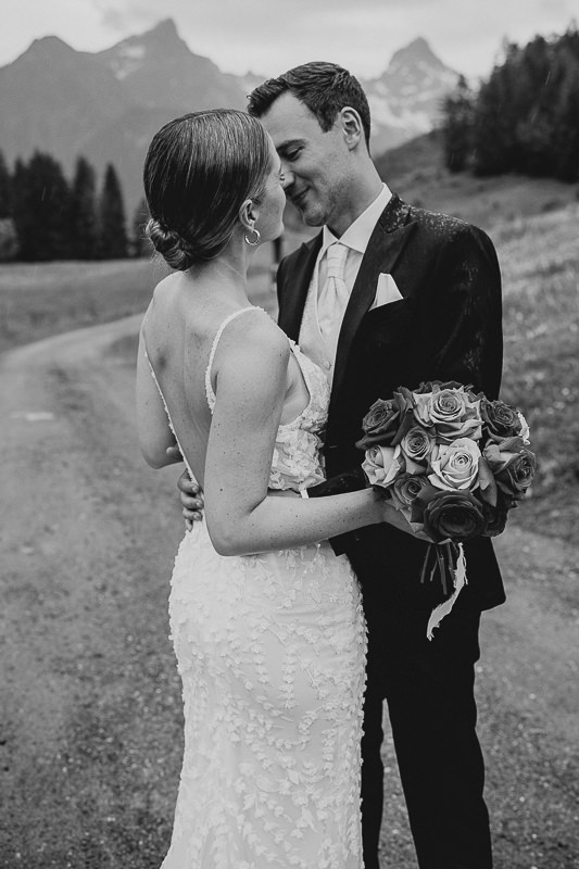 Braut und Bräutigam umarmen sich liebevoll vor der Bergkulisse der Rufana Alp in Tirol – natürliche Hochzeitsfotografie von Patricia Hamann