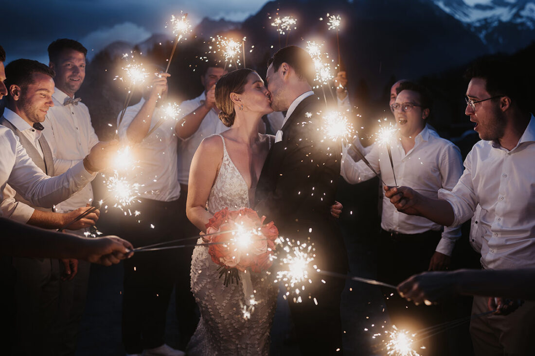 Hochzeitsfotograf Patricia Hamann zeigt Foto eines küssendes Brautpaare in Mitten von Wunderkerzen.