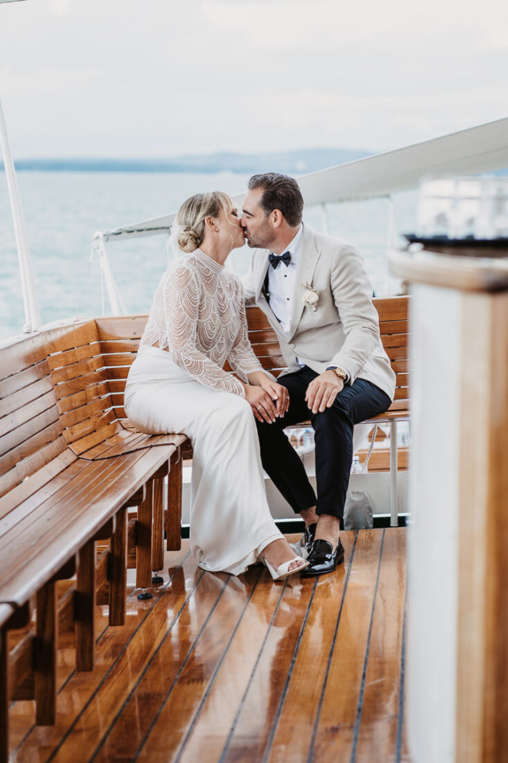Elegantes Brautpaar sitzt am Deck eines Schiffes auf dem Bodensee und küsst sich - Hochzeitsfotograf Patricia Hamann