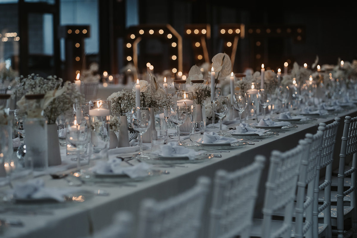 Üppig gedeckter Hochzeitstisch mit vielen Kerzen und Blumen