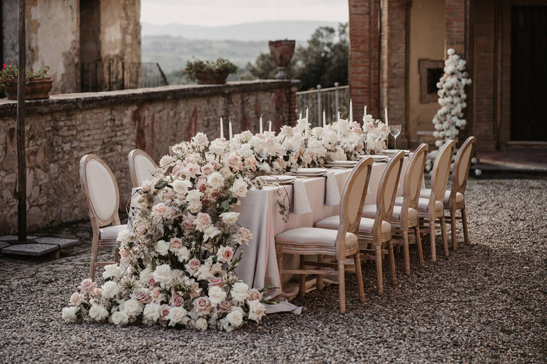 Mit Blumen geschmückter Hochzeitstisch im Freien bei einer Hochzeit in der Toskana