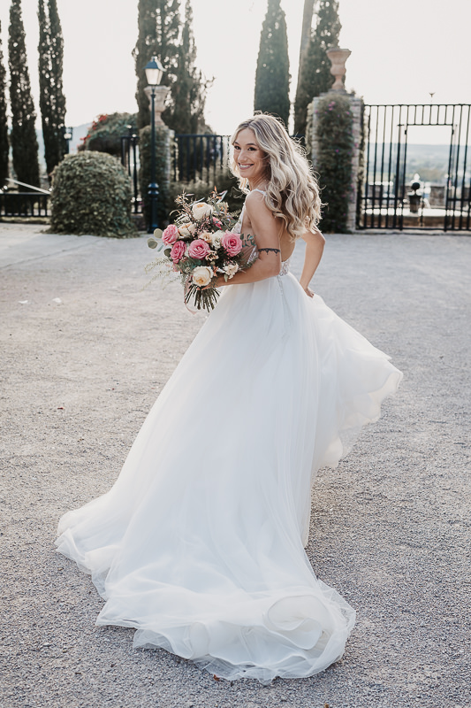 Portrait einer rennenden Braut im Sonnenlicht im Hof einer Finca auf Mallorca