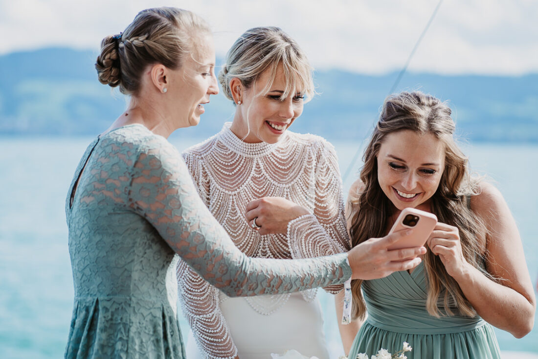 Braut lacht mit ihren Freundinnen auf einem Schiff auf dem Bodensee, fotografiert von Patricia Hamann, Hochzeitsfotograf Werft1919
