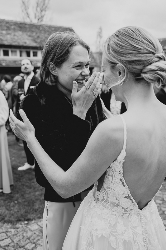 Die Braut lacht mit einer Freundin bei einer entspannten Hochzeit auf der Maisenburg, fotografiert von Patricia Hamann aus Ulm.