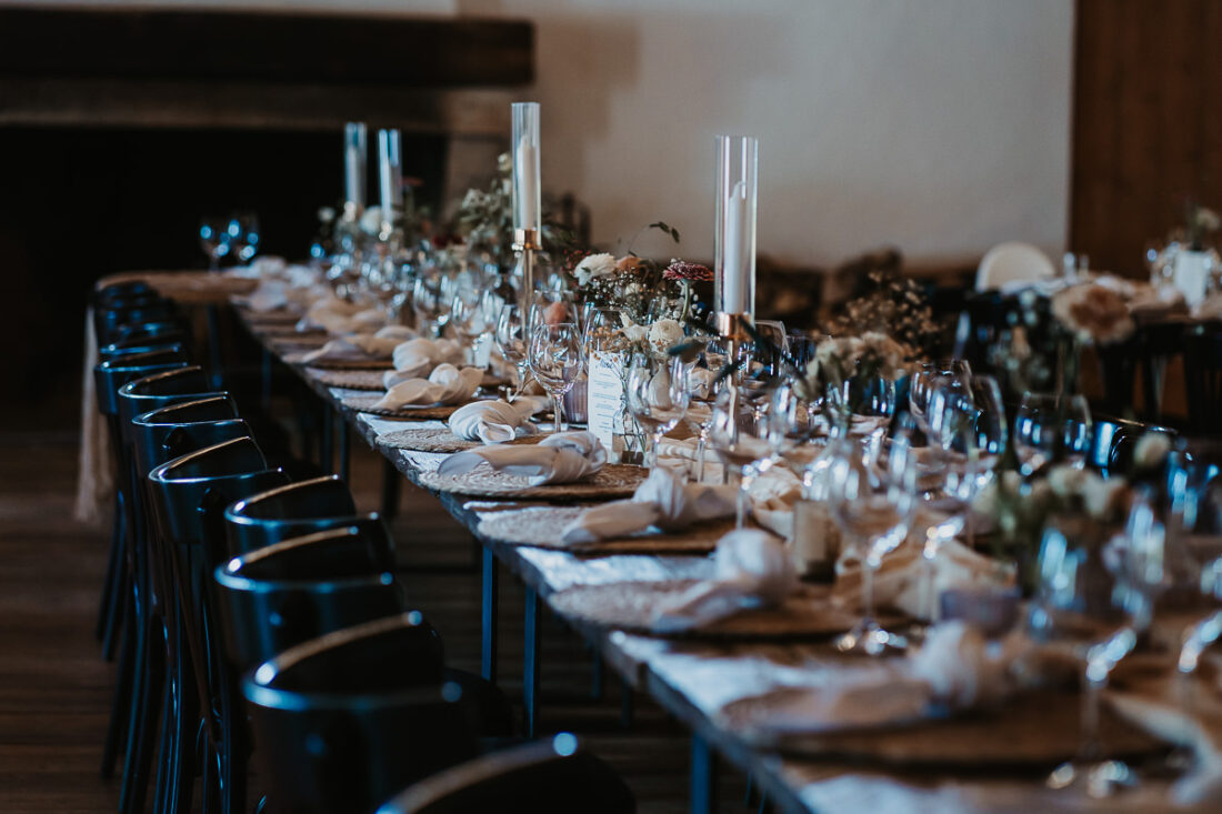 Stimmungsvoll gedeckte Hochzeitstafel mit Blumen, Kerzen und Glasdekoration in der Maisenburg. Fotografiert von Patricia Hamann, Hochzeitsfotografin aus Ulm.