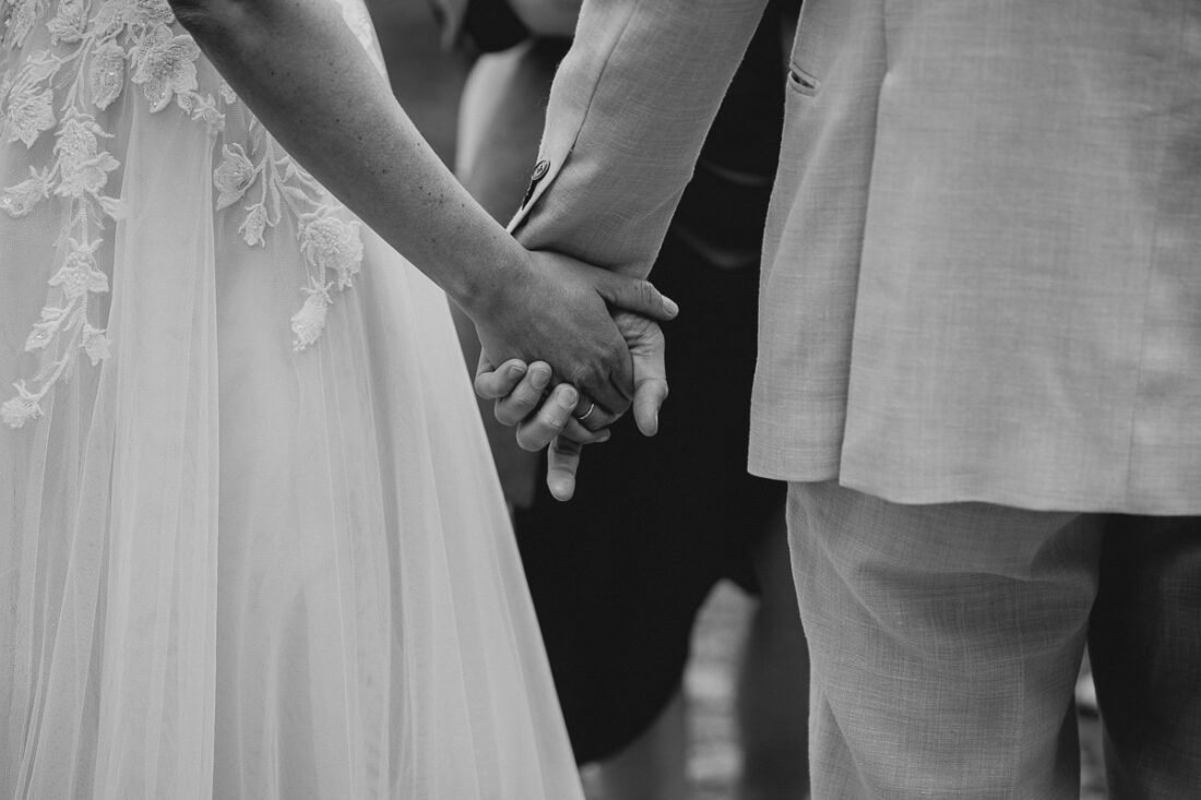 Ein Brautpaar hält sich zärtlich an den Händen während seiner Hochzeit auf der Maisenburg, festgehalten von Hochzeitsfotografin Patricia Hamann aus Ulm.