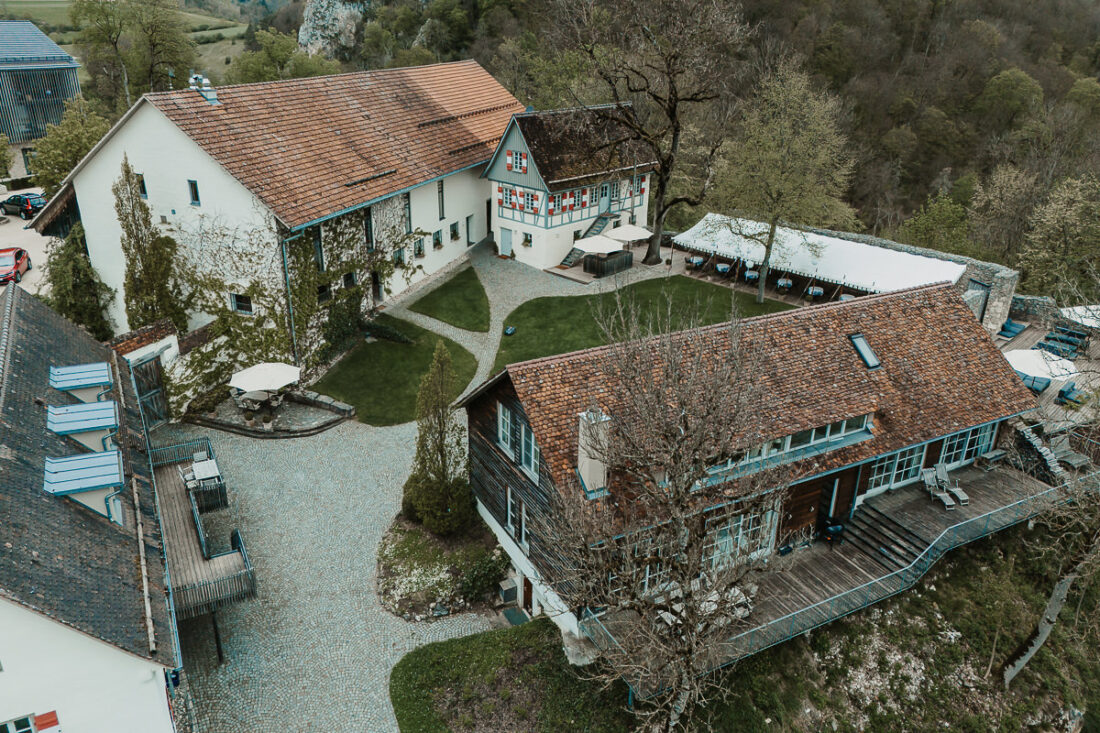 Drohnenaufnahme der Maisenburg mit Innenhof, Scheunen, Garten und umliegender Natur. Hochzeitslocation fotografiert von Patricia Hamann, Hochzeitsfotografin aus Ulm.