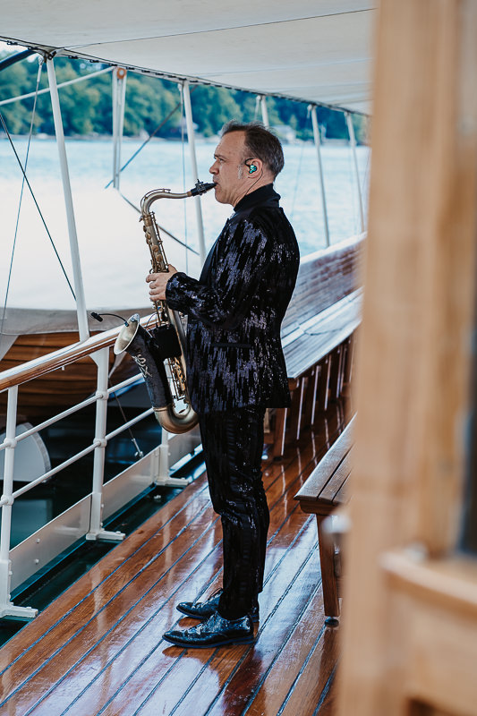 Saxophonist spielt live auf dem Deck der Hohentwiel während einer Hochzeit auf dem Bodensee, fotografiert von Patricia Hamann, Hochzeitsfotograf Werft1919