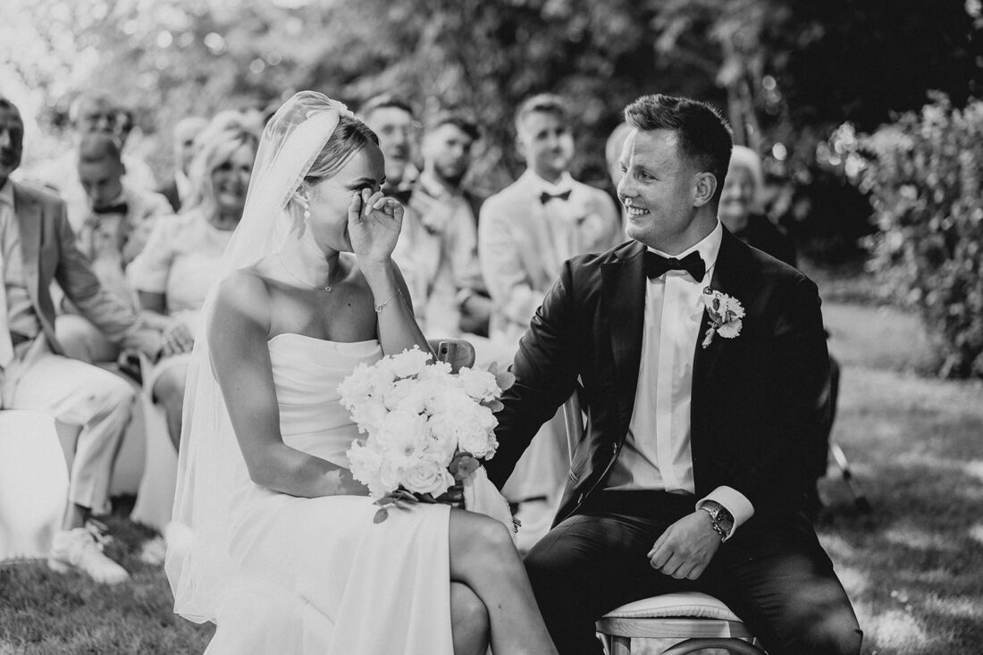 Rührender Moment während der Trauung: Die Braut wischt sich Tränen aus den Augen, während der Bräutigam ihre Hand hält, aufgenommen auf Ibiza.