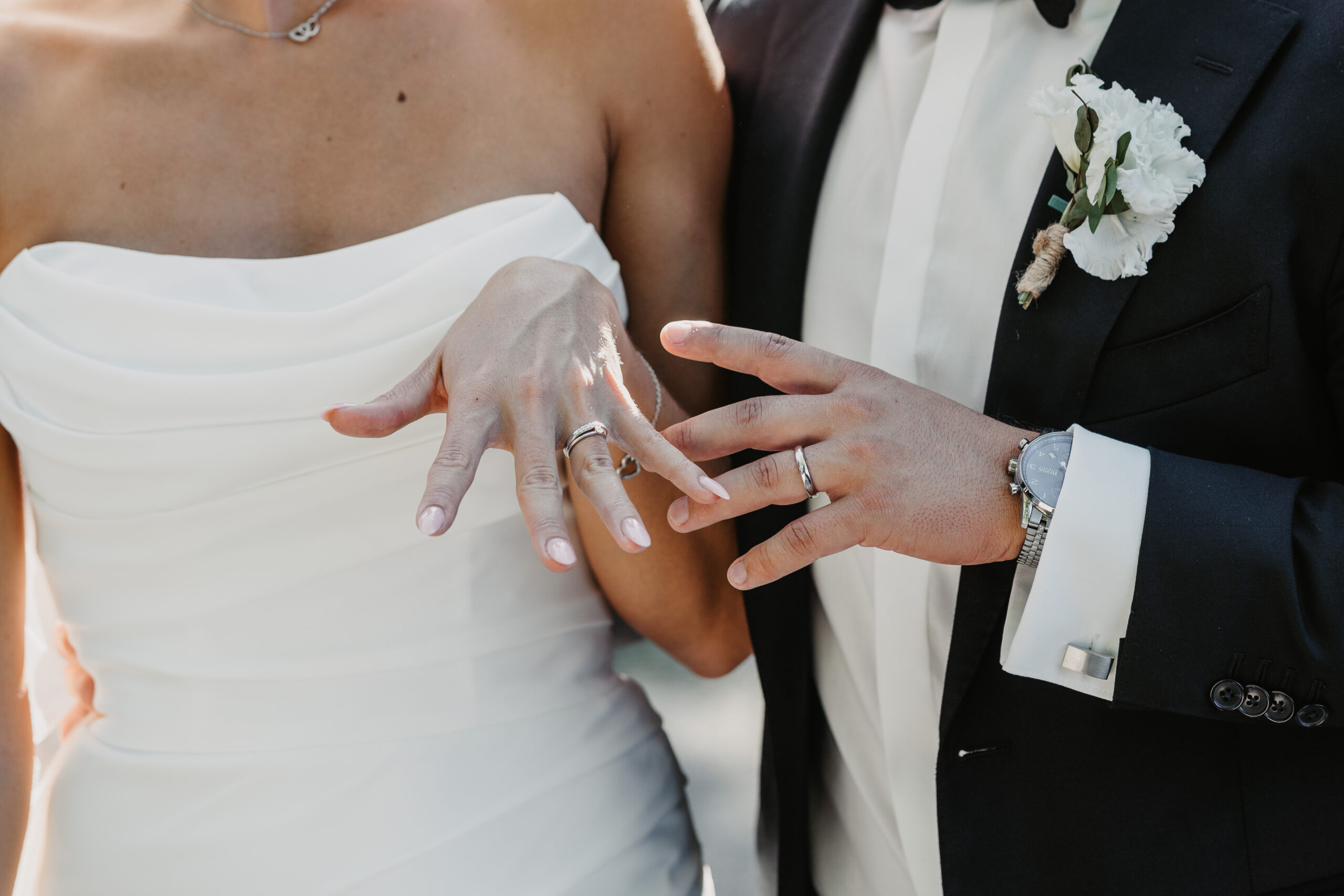 Nahaufnahme der frisch angelegten Eheringe eines Brautpaares, das stolz ihre Hände zeigt – aufgenommen während einer Hochzeit auf Ibiza.
