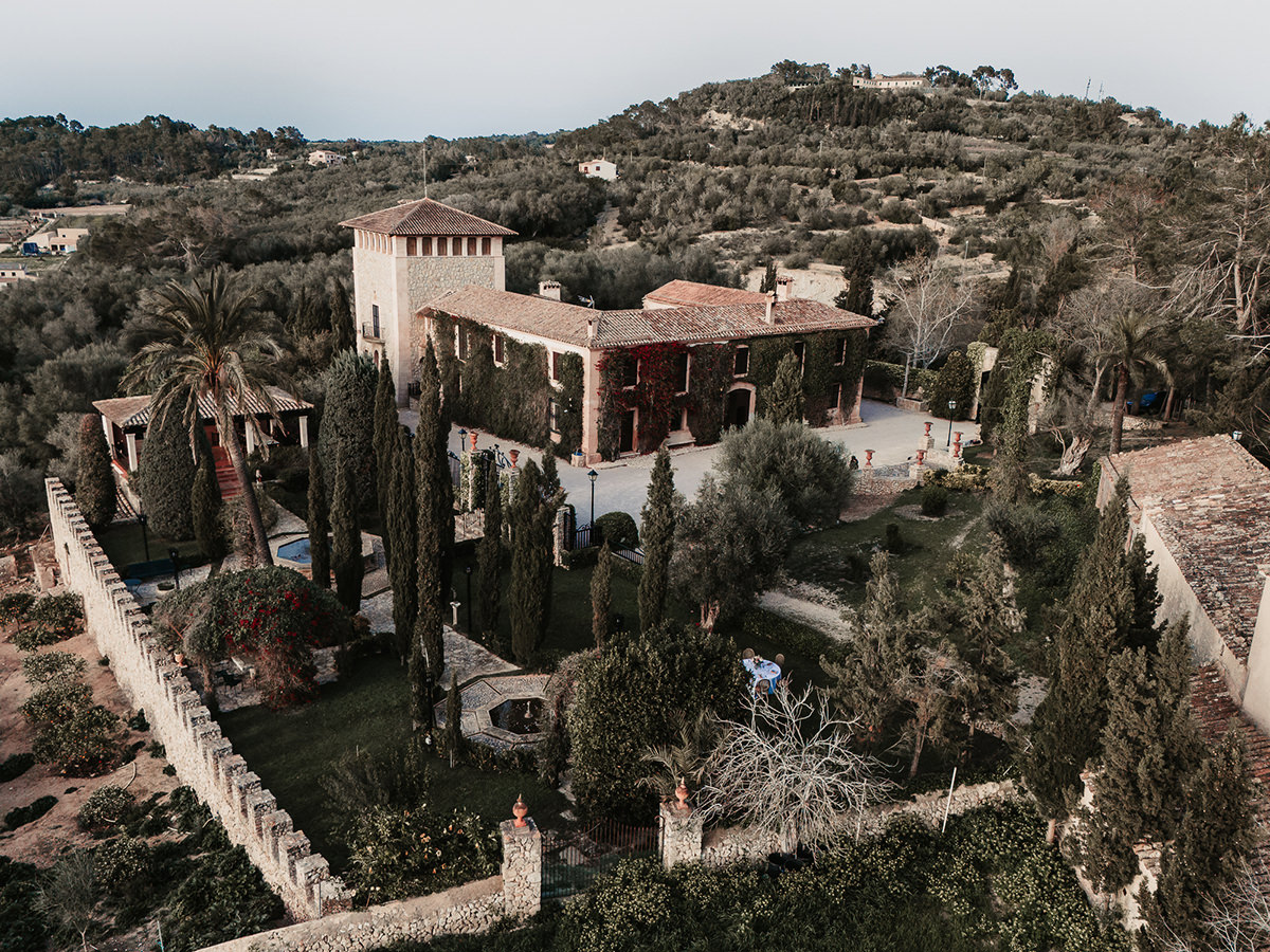 Atemberaubende Hochzeitslocation auf Ibiza aus der Luft, umgeben von mediterraner Landschaft und historischen Mauern.