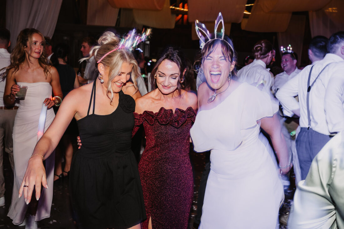 Freundinnen tanzen ausgelassen auf der Hochzeitsfeier auf dem Steinbachhof bei Stuttgart.