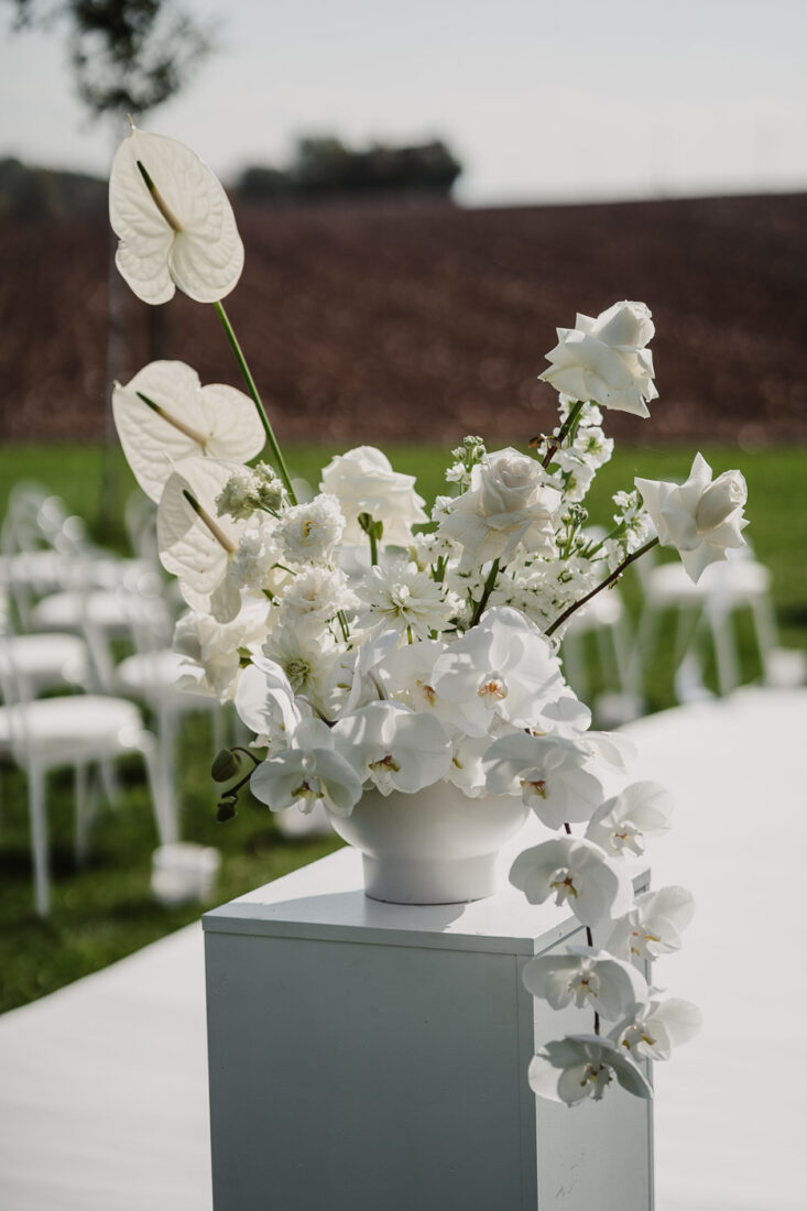 Detail der weißen Hochzeitsfloristik auf einer Stele am Gang zur freien Trauung bei Stuttgart.