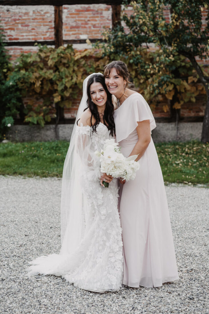 Die Braut und ihre erste Brautjungfer lachen herzlich in die Kamera während einer Hochzeitsfeier auf dem Steinbachhof.
