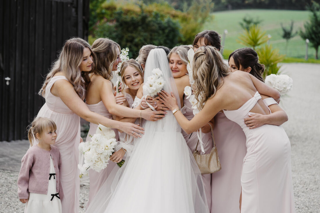 Große Gruppenumarmung der Braut und ihrer acht Brautjungfern nach dem First Look im Steinbachhof.