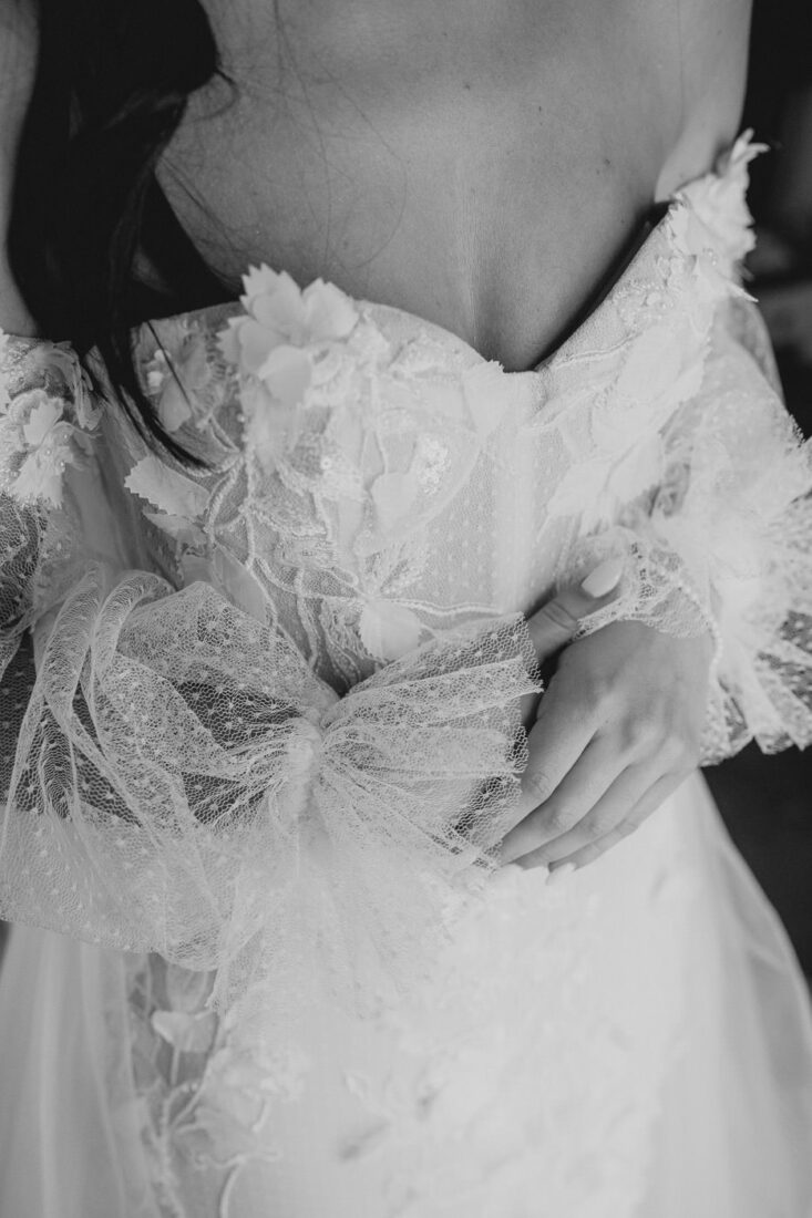 Detailaufnahme des Brautkleides mit Spitze und Tüll.