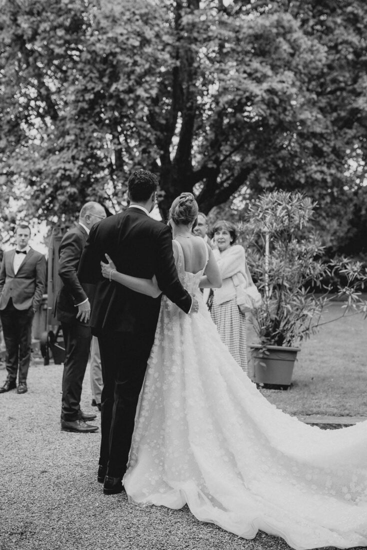 Brautpaar läuft Arm in Arm durch den Garten des Hotel Bad Schachen in Lindau am Bodensee.