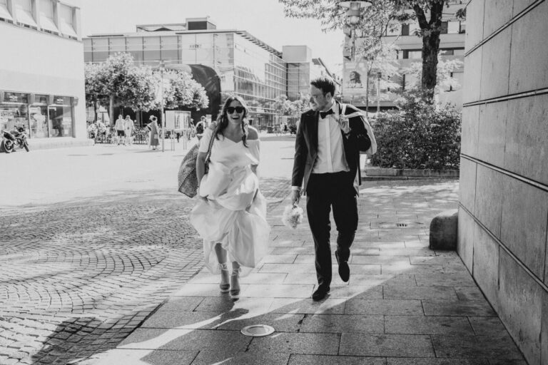 Brautpaar läuft lachend durch die Innenstadt von Friedrichshafen nach der Trauung am Bodensee.