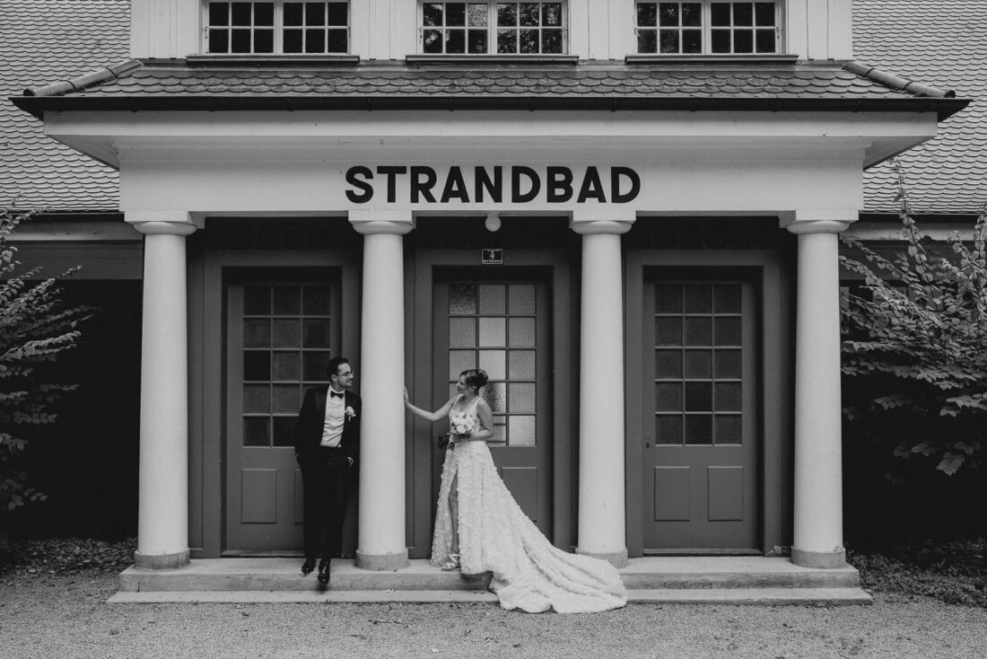 Das Brautpaar lehtn an den Säulen des historischen Strandbads in Lindau