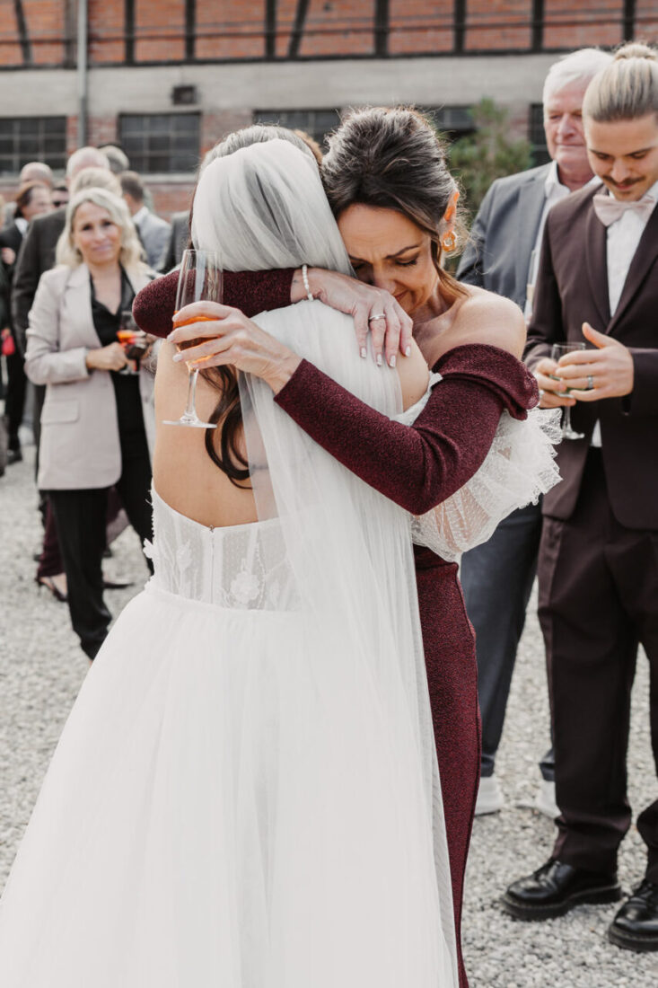 Innige Umarmung zwischen Braut und Mutter während der Gratulation nach der Trauung.