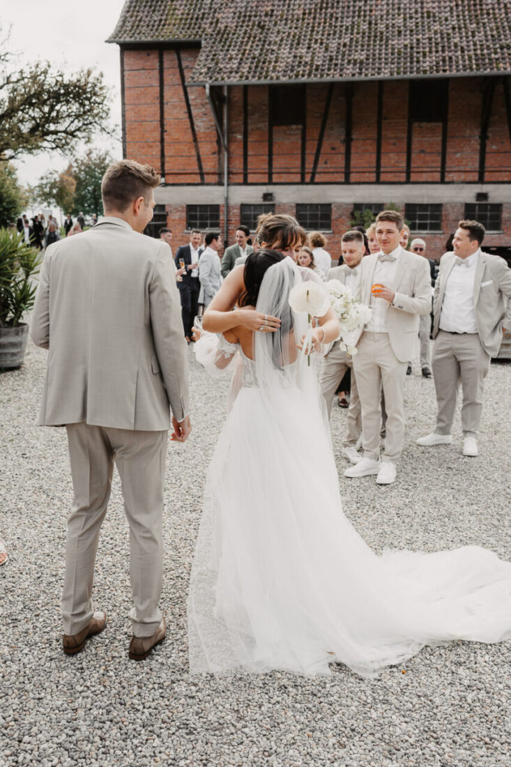 Emotionale Umarmung und Glückwünsche für das Brautpaar vor der historischen Scheune des Steinbachhofs.
