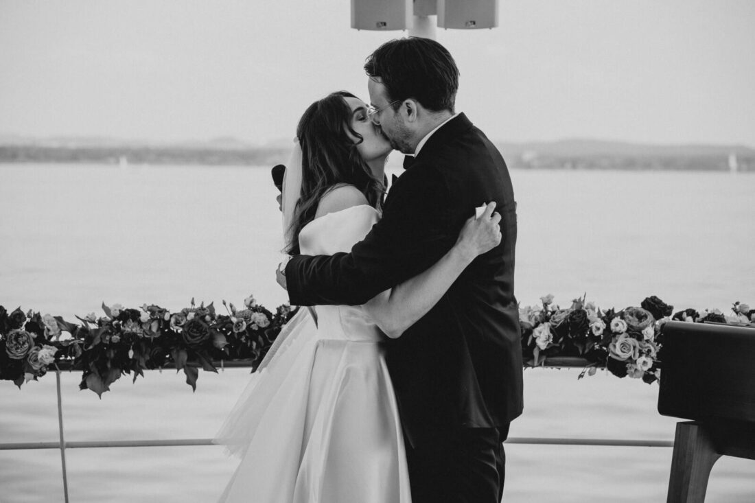 Emotionaler erster Kuss des Brautpaares nach der Trauzeremonie auf dem Außendeck der MS Säntis vor der Kulisse des Bodensees.