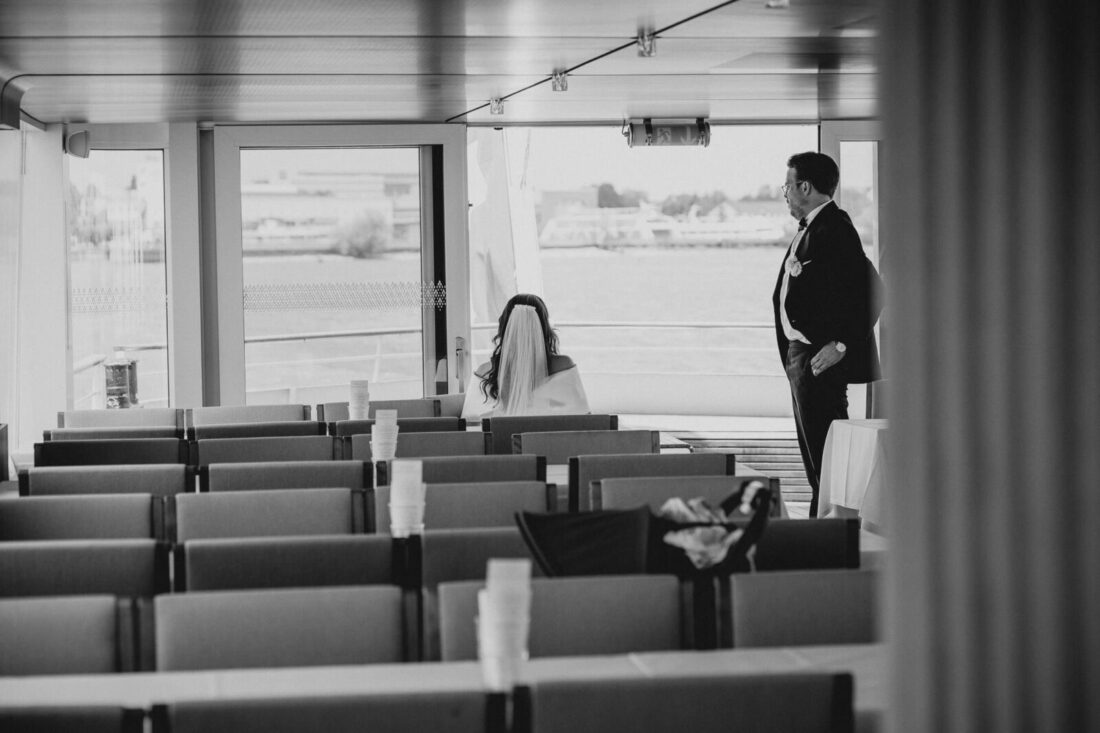 Das Brautpaar steht in einem ruhigen Moment allein im leeren Passagierbereich der MS Säntis und blickt auf den Bodensee.