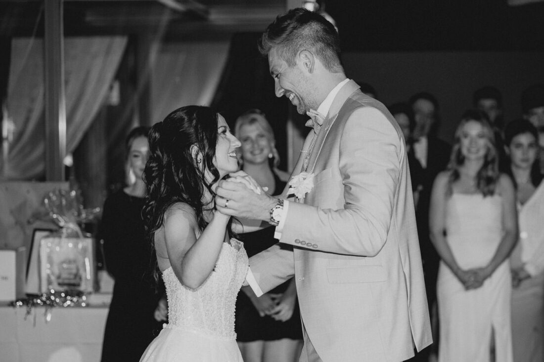 Brautpaar lacht sich beim Eröffnungstanz auf ihrer Hochzeit liebevoll an.