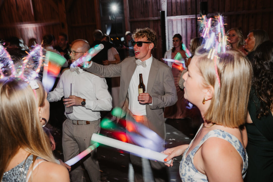 Hochzeitsgäste tanzen mit Lichtstäben auf der Feier im Raum Stuttgart.