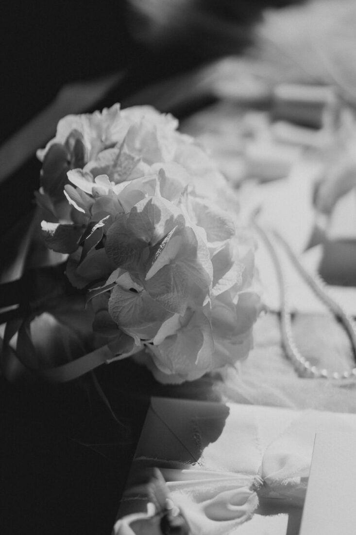 Nahaufnahme von Hochzeitsblumen und Papeterie beim Getting Ready der Braut auf dem Steinbachhof.