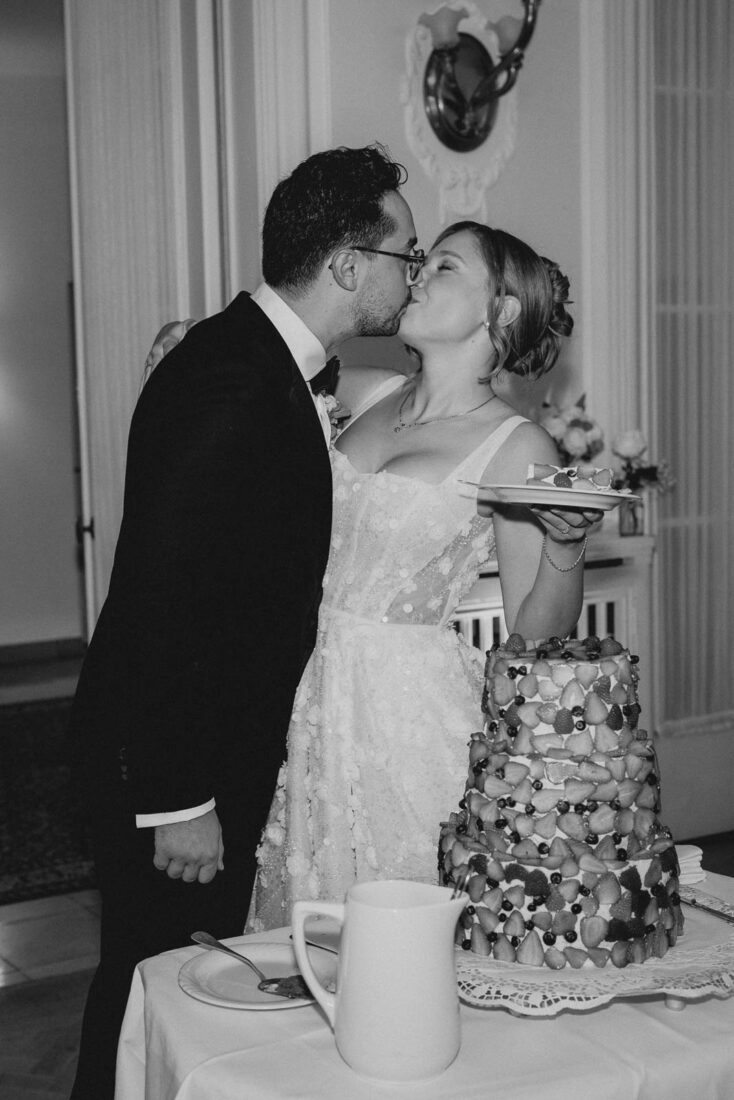 Brautpaar küsst sich beim Tortenanschitt im festlichen Saal des Hotel Bad Schachen.