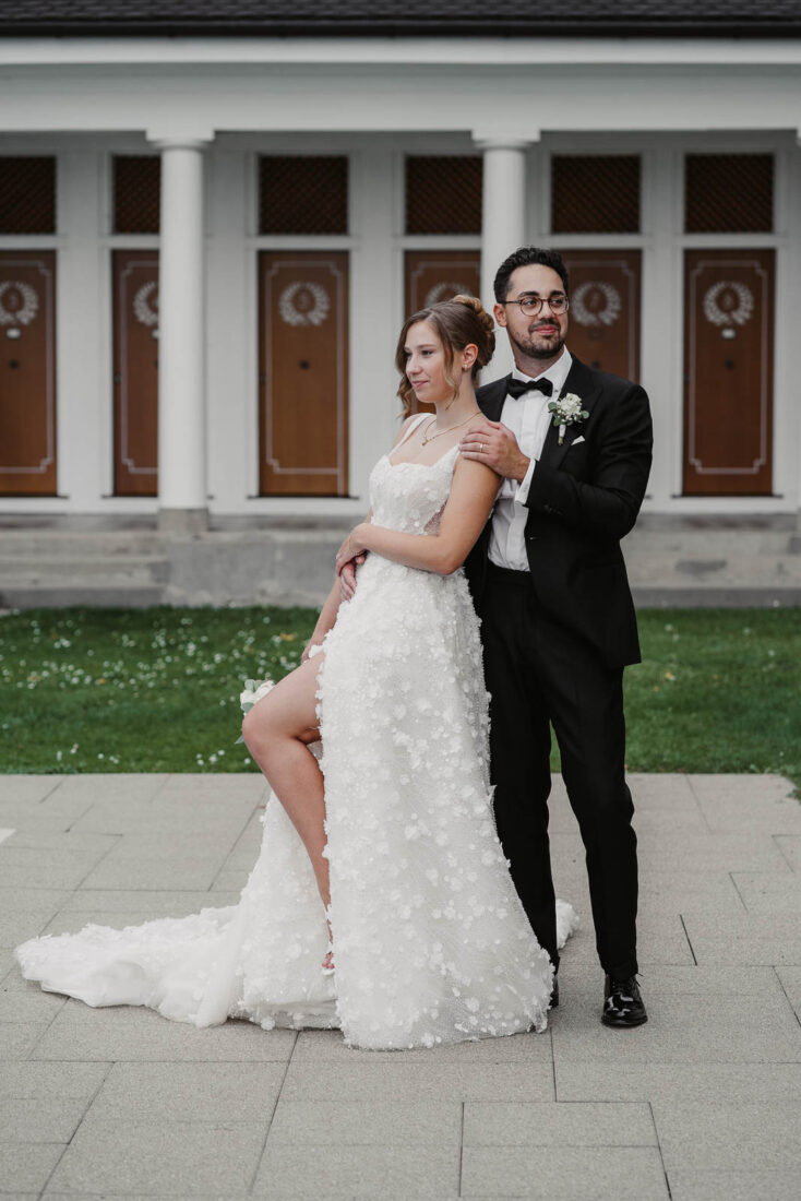 Elegante Pose des Brautpaares vor der symmetrischen Fassade des Strandbads Bad Schachen.