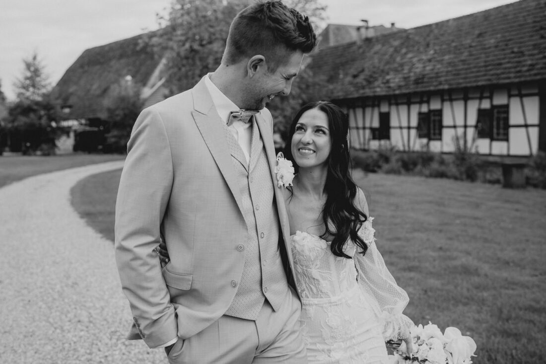 Brautpaar spaziert entspannt über das Gelände des Steinbachhofs bei Stuttgart und sieht sich dabei verliebt an.