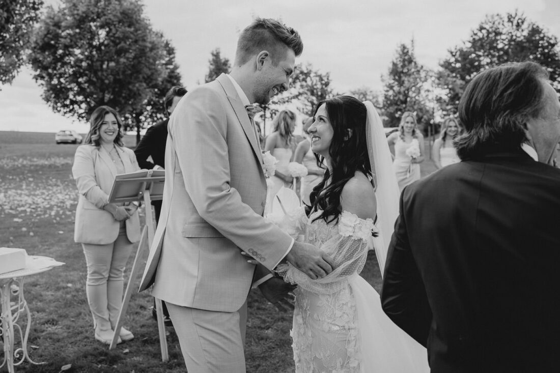 Ein glückliches Brautpaar blickt sich zum ersten Mal bei der freien Trauung auf dem Steinbachhof bei Ludwigsburg tief in die Augen.