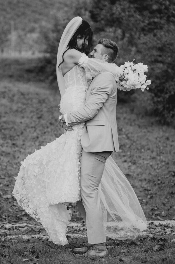 Bräutigam hebt die Braut in die Luft während dem Brautpaarshooting auf dem Steinbachhof bei Ludwigsburg.