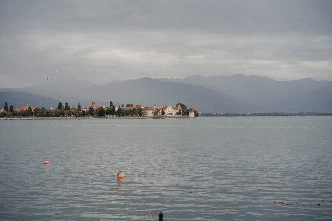 Blick über den Bodensee auf die Halbinsel Lindau unter einem bewölkten Himmel.