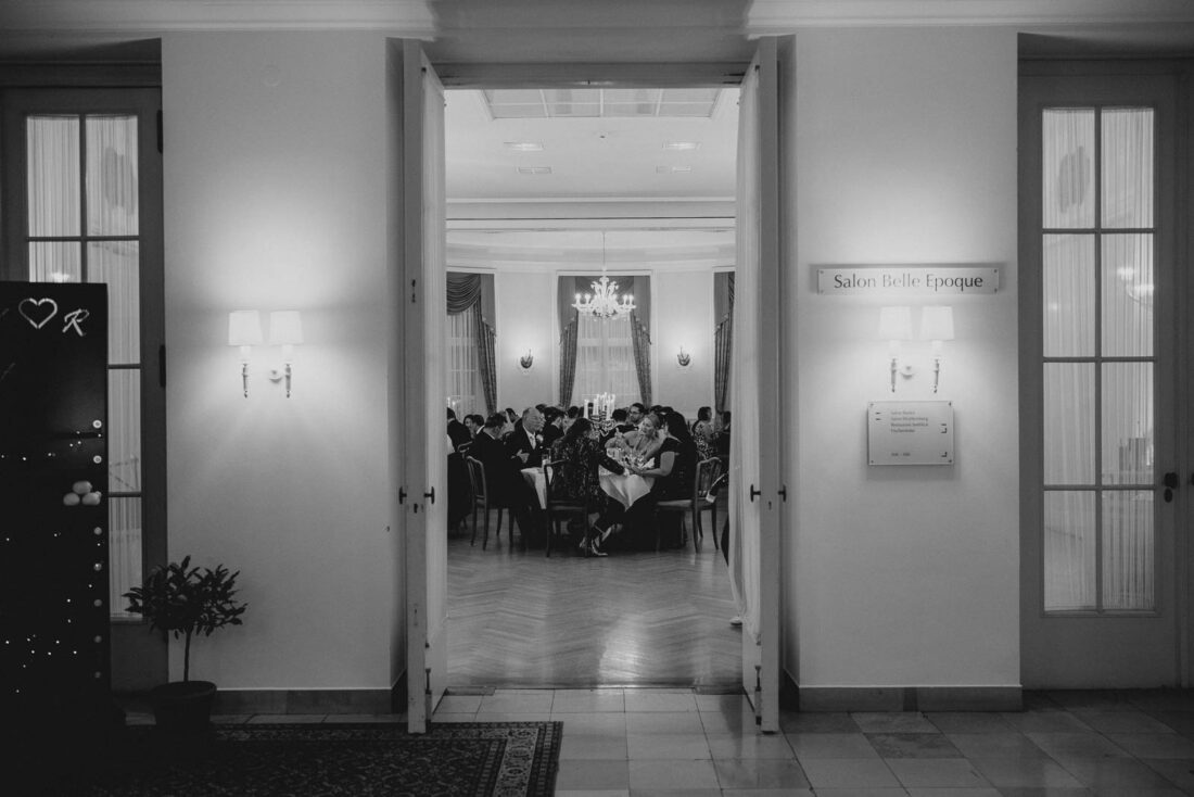 Blick durch die geöffnete Flügeltür in den festlich erleuchteten "Salon Belle Epoque" im Hotel Bad Schachen.