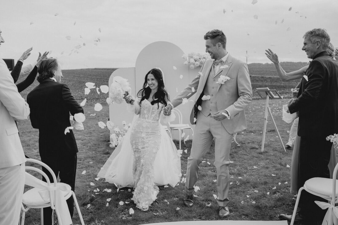 Weitwinkelaufnahme des Brautpaares beim Auszug auf dem weitläufigen Gelände des Steinbachhofs.