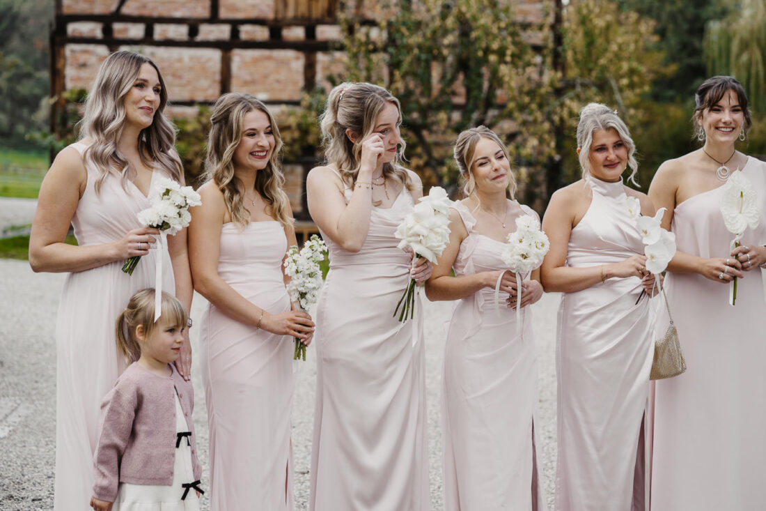 Eine Reihe lachender Brautjungfern blickt voller Bewunderung auf die Braut während der Hochzeit im Kreis Ludwigsburg.
