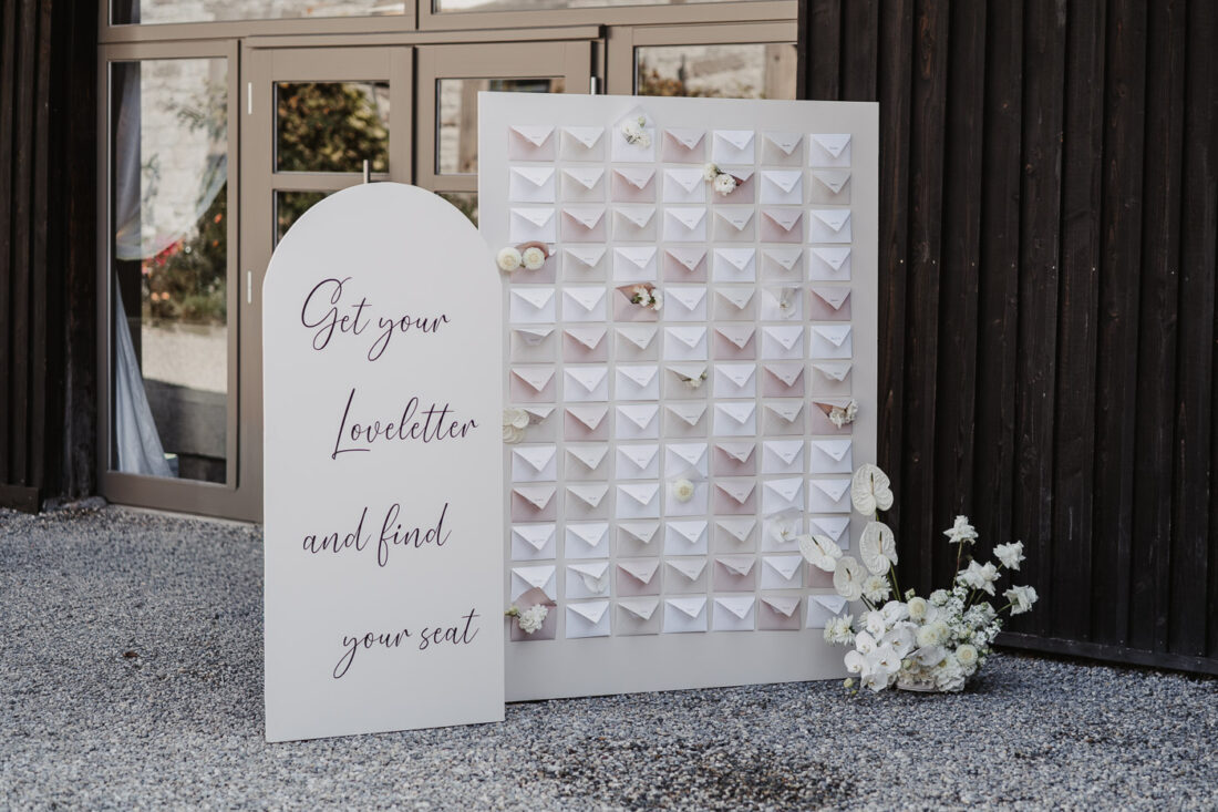 Kreativer Sitzplan mit Briefumschlägen und Blumen-Deko bei einer Hochzeit im Raum Stuttgart.
