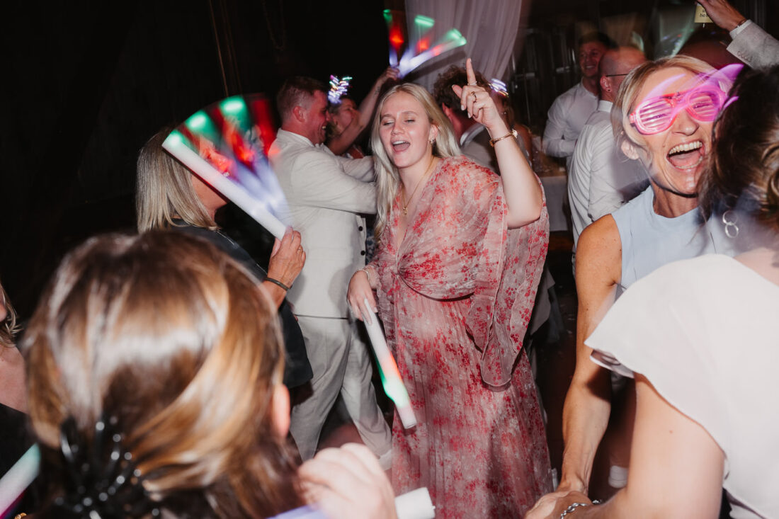 Die Gäste tanzen ausgelassen mit Sonnenbrillen und Leuchtstäben auf der Hochzeitsparty in der Nähe von Stuttgart