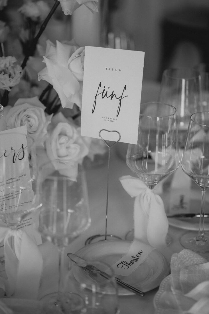 Schwarz-Weiß-Detailaufnahme der Tischnummer „Fünf“ und floraler Deko am Steinbachhof Stuttgart.