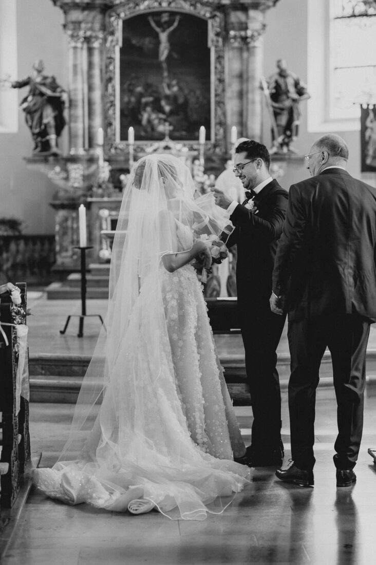 S/W Foto: Der Bräutigam lüftet den Schleier der Braut während der Trauzeremonie in Lindau.