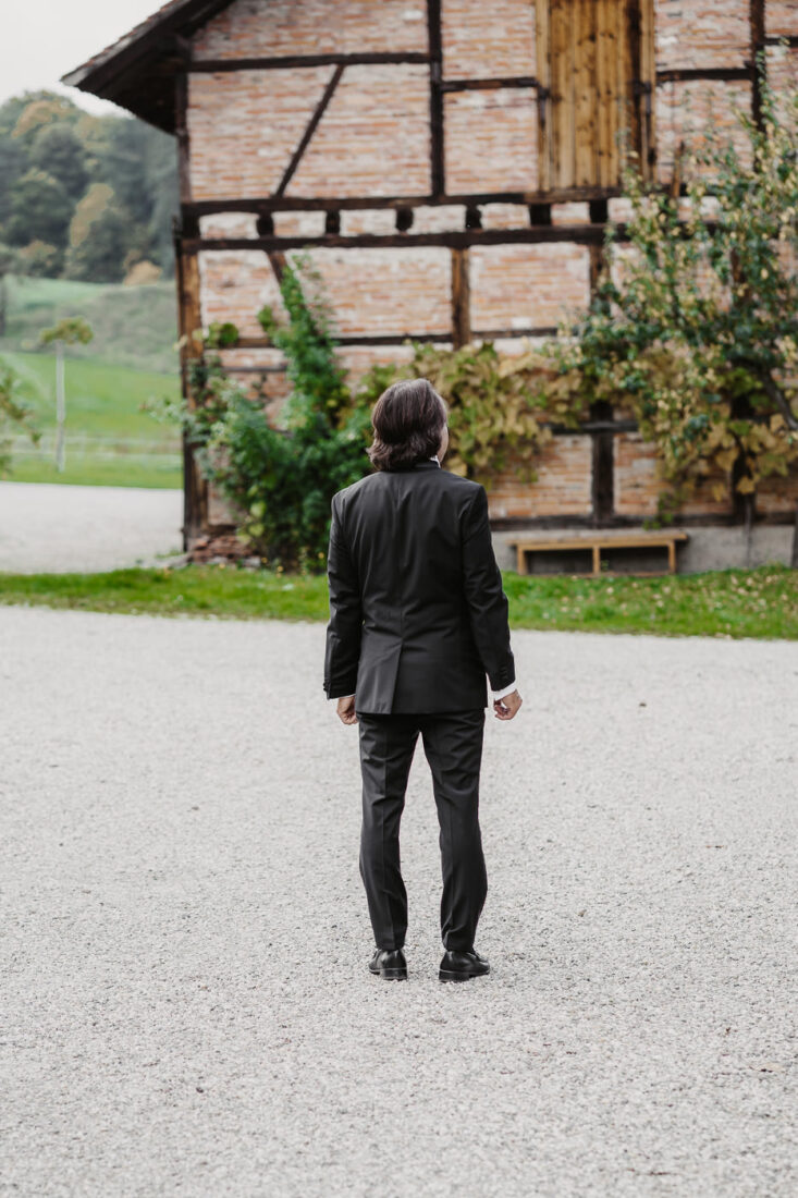 Ein Vater steht mit dem Rücken zur Kamera auf dem Kiesweg des Steinbachhofs und wartet auf seine Tochter.