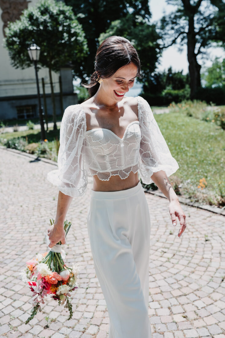 Braut im modernen Zweiteiler vor dem Museumssaal Überlingen am Bodensee.